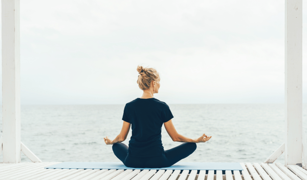 Women meditating by the ocean.