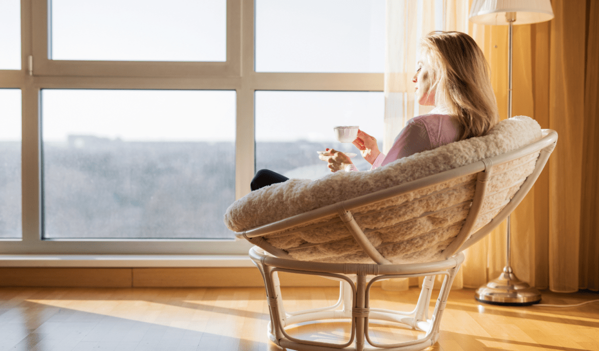 Women sitting in a chair calmly relaxing with a cup of tea.