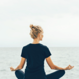 A women meditate calmly by the ocean