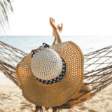 Women relaxing in hammock on holiday at the beach doing nothing