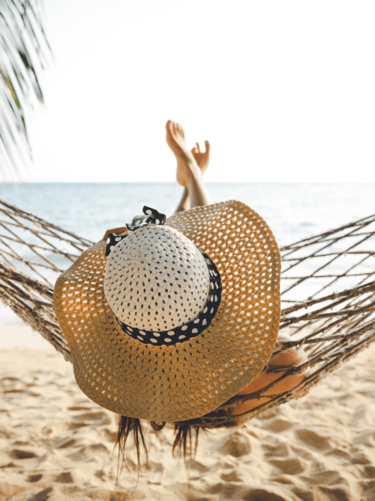 Women relaxing in hammock on holiday at the beach doing nothing