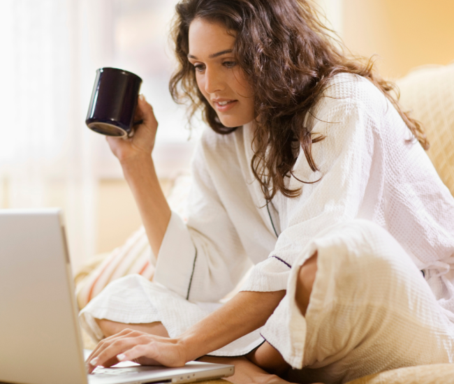 Holistic practitioner working calm at computer with cup of tea